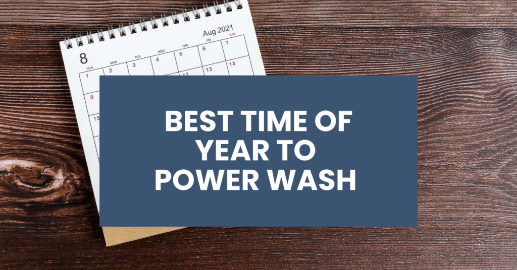 A calendar open to August 2021 sits on a wooden surface, partially covered by a blue box with white text that reads, "Best Time of Year to Power Wash.