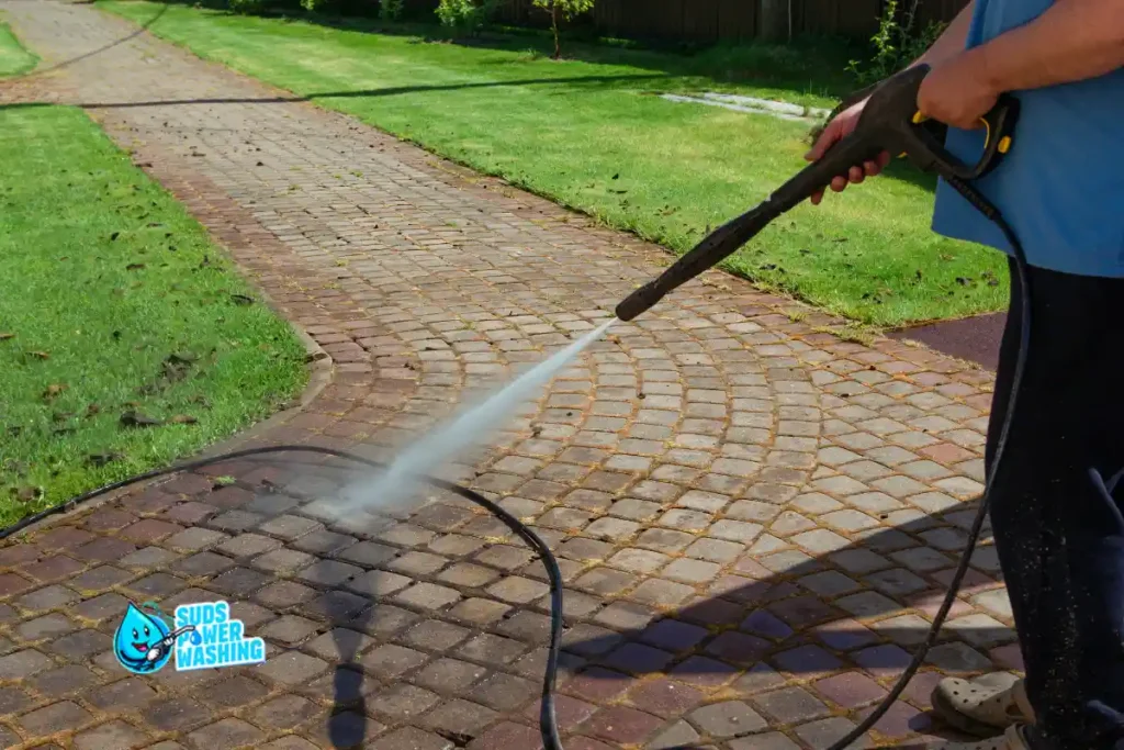 Residential power washing Pennsylvania โ homeowner cleaning brick paver driveway before booking professional service
